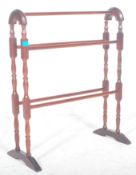 A 20th century Victorian revival mahogany arched towel rail raised on turned supports united by five