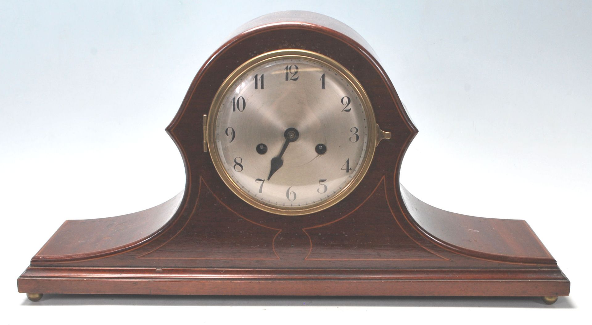 An early 20th Century Edwardian mahogany napoleon's hat mantel clock having inlaid borders with a