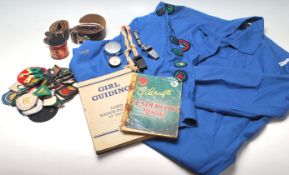 A quantity of vintage 20th Century girl guide related items to include belt, whistle, fabric badges,