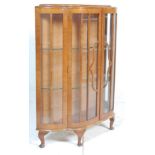 A vintage mid 20th Century walnut China display cabinet having a serpentine front with glazed panels