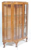 A vintage mid 20th Century walnut China display cabinet having a serpentine front with glazed panels