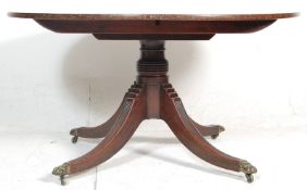 A 20th Century antique mahogany tilt top pedestal  dining table having a round top raised on a