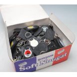 A large collection of vintage retro car key rings having black back plastic, metal ring atop and