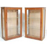 A pair of vintage mid Century walnut veneer china cabinets of rectangular upright form having having