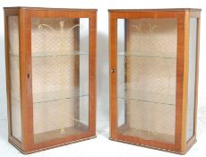 A pair of vintage mid Century walnut veneer china cabinets of rectangular upright form having having