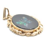 A 9ct gold hallmarked pendant of oval form set with an oval black stone panel with opalescent