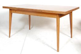 A mid 20th century retro Danish inspired teak wood extended dining table. The rectangular table