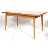 A mid 20th century retro Danish inspired teak wood extended dining table. The rectangular table