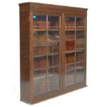 An early 20th century antique mahogany upright glazed library bookcase cabinet having twin