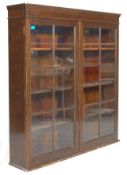 An early 20th century antique mahogany upright glazed library bookcase cabinet having twin