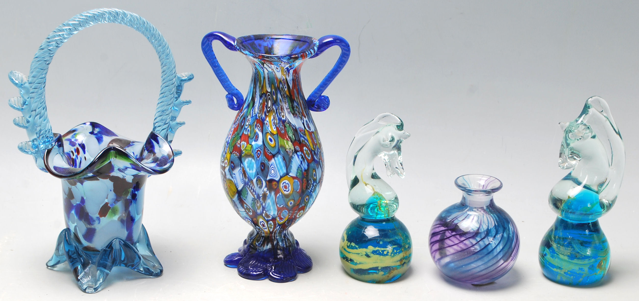 A collection of Murano and Mdina glass to include a pair of horse head paper weights, flower