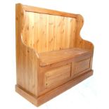 A 20th Century vintage country pine two seat monks bench / hall settle chest having wing back