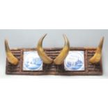 Early 20th century tribal inspired coat rack having four bovine horns flanked by two blue and