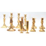 A good collection of mid 20th Century brass candlesticks raised on squared, circular and oval