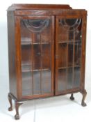 A 1930's Art Deco oak bow front library  bookcase cabinet. The cabinet having a raised back over