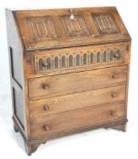 A Jacobean revival 1930's oak bureau decorated with linen fold motif having a fall front desk to