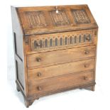 A Jacobean revival 1930's oak bureau decorated with linen fold motif having a fall front desk to