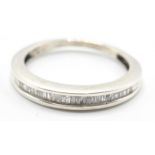 A white gold ladies dress ring with channel set diamonds in a half eternity setting. Size L.