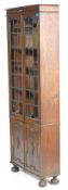 A 1920’s Arts & Crafts oak tall library bookcase cabinet with adjustable shelves, twin leaded and