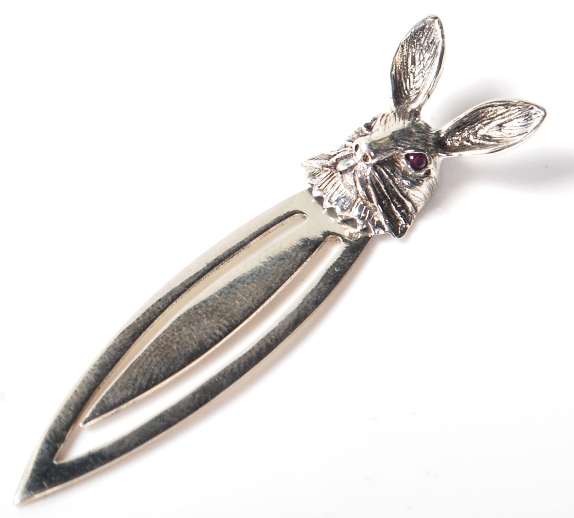 A sterling silver bookmark having a rabbits head finial and inset with red stones. Weighs 4g.
