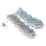 A pair of silver and aquamarine ladies dress earrings set with blue stones within a honeycomb