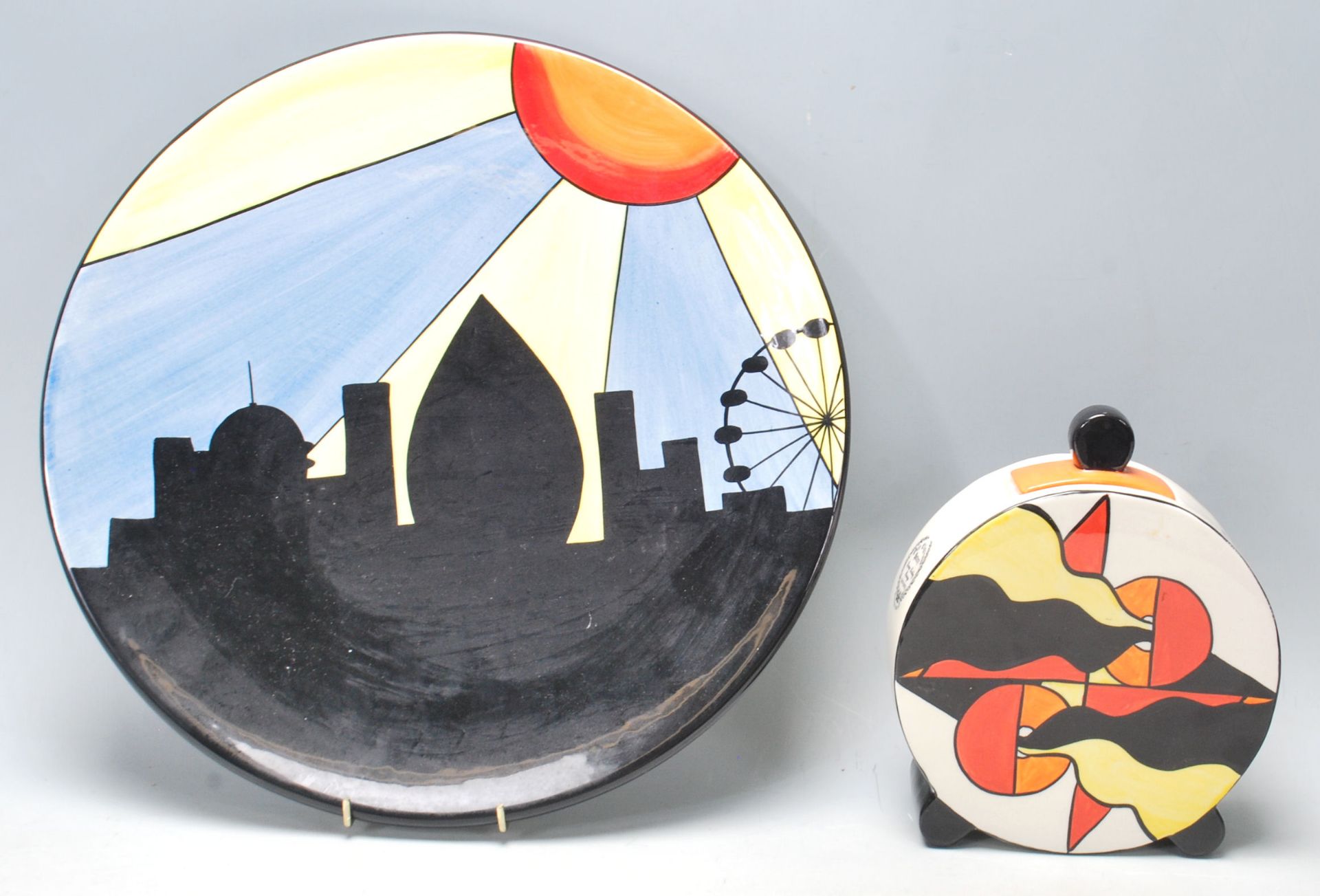 Lorna Bailey ceramic charger plate being hand painted with black, blue, yellow and orange colours,