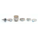 A group of six silver rings to include three rings set with square cut blue stones, a ring set