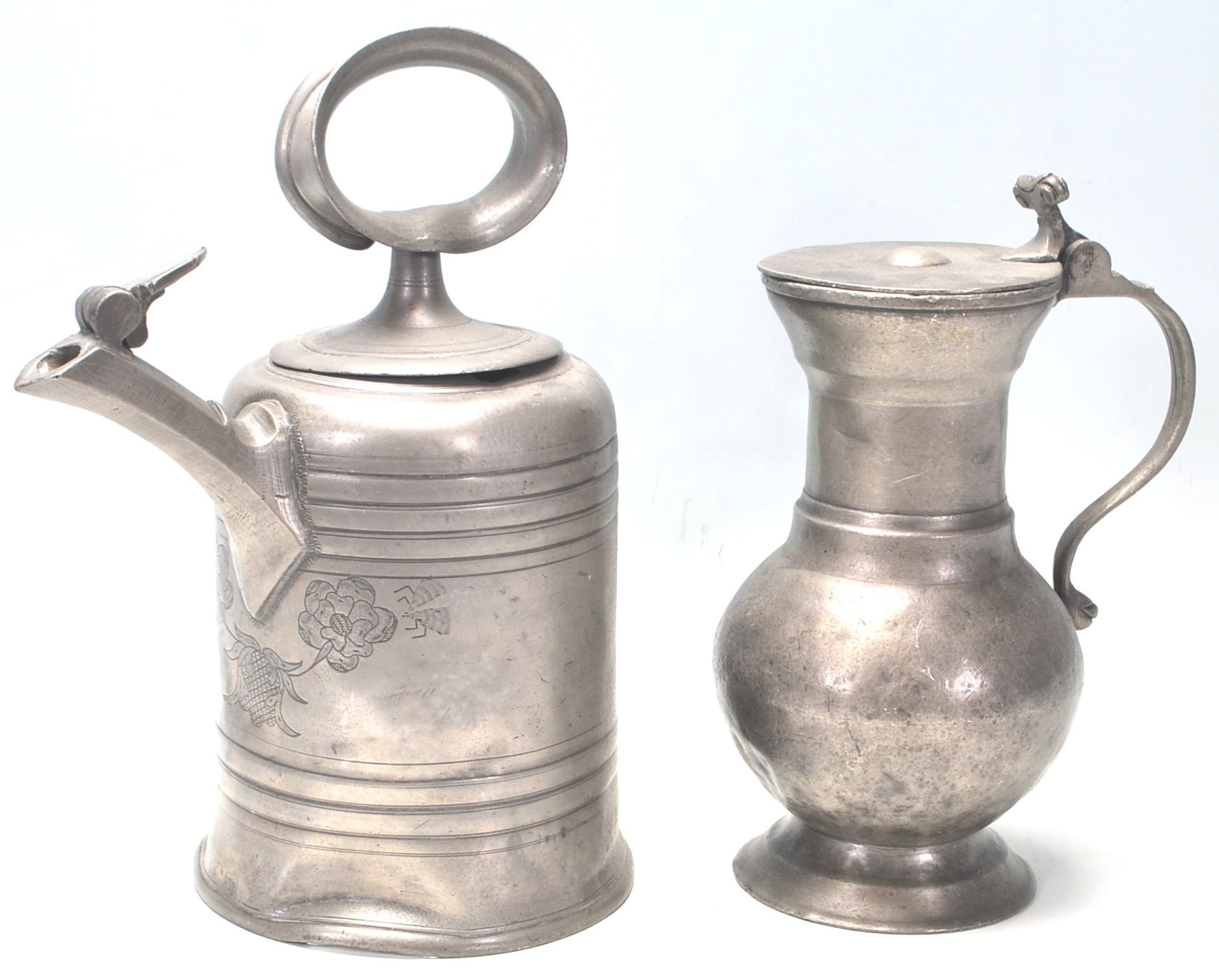 An 18th Century German pewter vessel / tankard having bulbous form with scroll handle sitting on