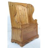 A contemporary antique style vintage two seat country pine pine monks bench with shaped arm rests