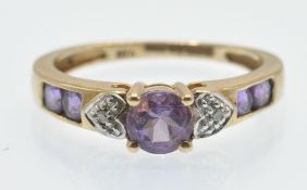 A hallmarked 9ct gold amethyst and diamond ring. The ring set with a central round mixed cut