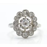 An 18ct white gold and diamond cluster ring. The r