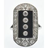 A platinum onyx and diamond plaque ring. The ring set with four round brilliant cut diamonds