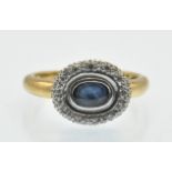 A hallmarked 18ct gold Sapphire and diamond cluster ring. The ring set with a central oval mixed cut