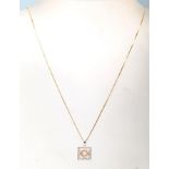 A 14ct mixed gold and diamond necklace having a pe