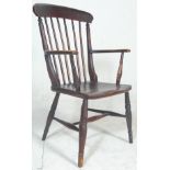 A Victorian 19th century beech and elm wood Windsor armchair being raised on turned legs united by