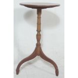 A 19th century George III mahogany tripod wine table being raised on splayed legs with turned