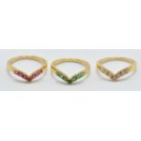 A set of three 18ct yellow gold wishbone style rings set with white diamond, rubies and emeralds
