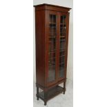 A early 20th century antique oak display cabinet having twin lattice doors opening to reveal
