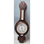 An early 20th century Made in England oak wall barometer. The heavy banjo barometer having