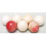 A early 20th century group of five antique ivory gaming balls. Colours include white and red balls.