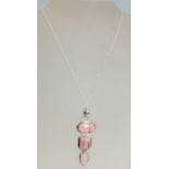 A 925 silver and rose quartz pendant necklace having three geometrical graduated rose stones.