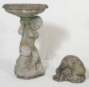 A late 20th century stone composite birdbath depicting a boy on a naturalistic base holding up the