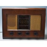 A vintage 20th Century walnut cased valve radio by Bush. Bush transfer logo to the top of the