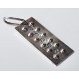 A 1977 silver ingot pendant and rectangular form having raised roundell decoration and pendant