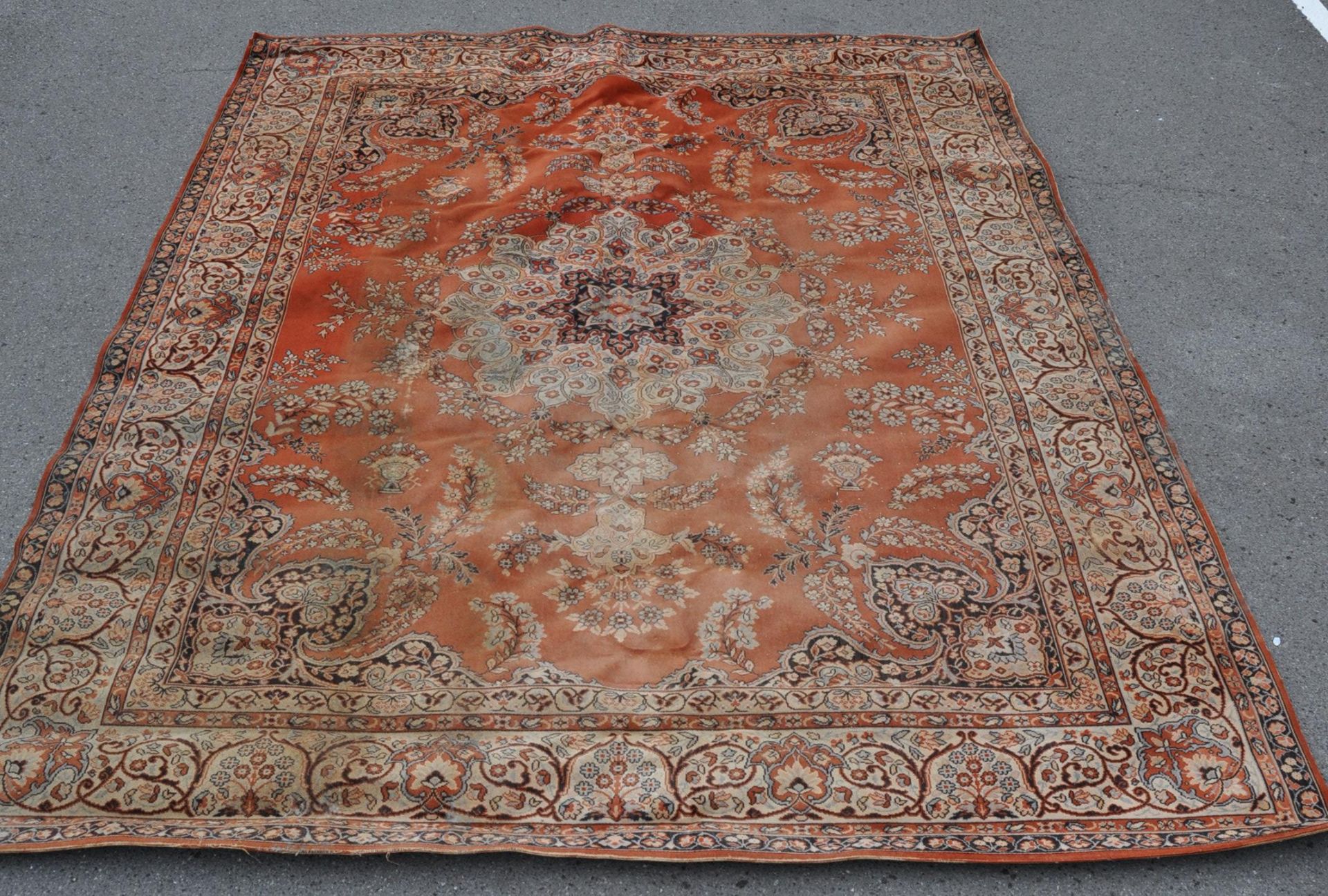 A large 20th century Persian / Islamic inspired woollen rug. The large floor carpet run with red