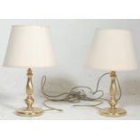 A pair of brass table lamps in the form of candlesticks, circa 20th century having terraced bases