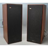 A pair of vintage Bang & Olufsen Beovox 1200 speakers with teak wood case and fabric front cover.