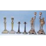 A collection of early 20th Century brass and spelter candlesticks to include a pair of figures stood