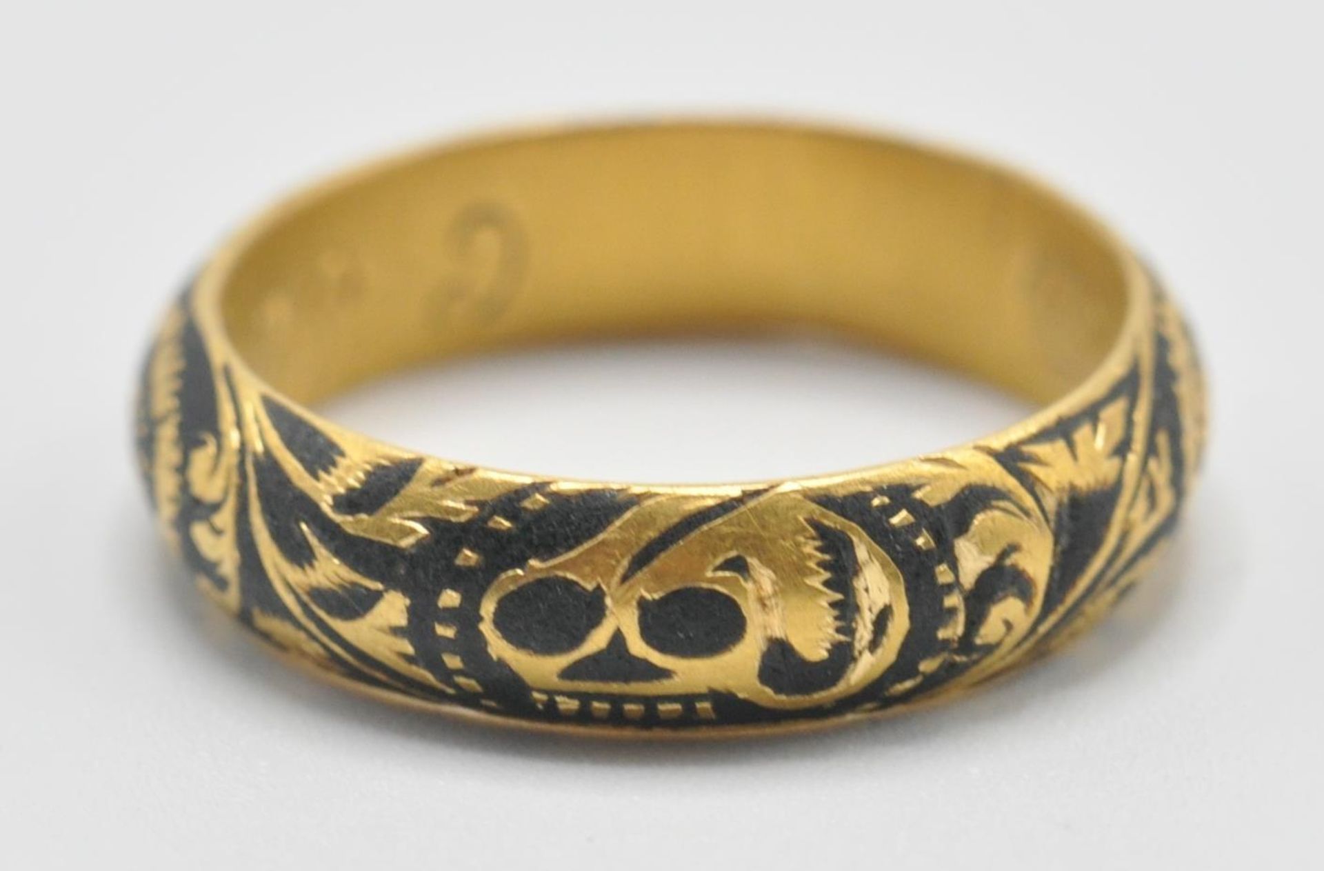 An early 18th Century gold memento mori mourning ring, the band being engraved with a skull and