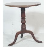 A 19th century Georgian oak wine table / tilt top table having circular top, turned column and